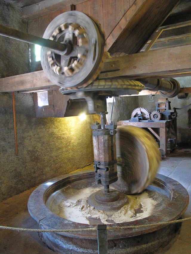 Wooden cogs set in bevel mortise wheels driving a millstone. Note wooden spur gears in the background.