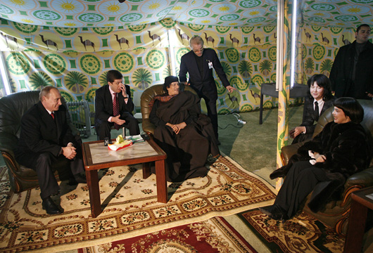 During his 2008 visit to Russia, Gaddafi pitched his Bedouin tent in the grounds of the Moscow Kremlin. Here he is joined by Russian Prime Minister Vladimir Putin and French singer Mireille Mathieu.