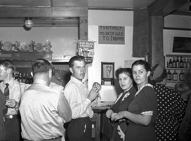 A discriminatory sign posted above a bar. Birney, Montana, 1941