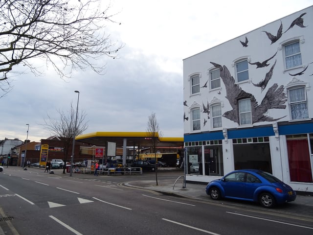 Petrol station at the site of 517 High Road, Leytonstone, where Hitchcock was born; commemorative mural at nos. 527–533 (right).