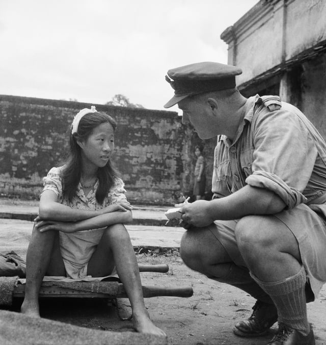 A young ethnic Chinese woman who was in one of the Imperial Japanese Army's "comfort battalions" is interviewed by an Allied officer (see Comfort women).