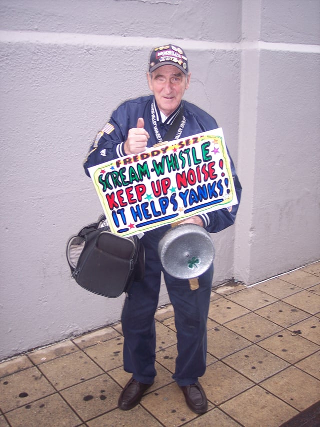 "Freddy Sez" holding one of his signs near the bleachers entrance before a game between the Yankees and the Texas Rangers