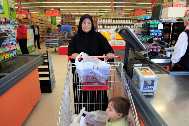 A woman in Jordan is ready to pay for her groceries.