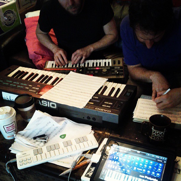 People composing music in 2013 using electronic keyboards and computers.