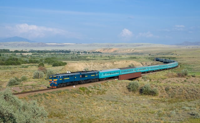 Train 22 Kyzylorda – Semipalatinsk, hauled by a Kazakhstan Temir Zholy 2TE10U diesel locomotive. Picture taken near Aynabulak, Kazakhstan.