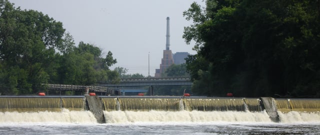 The North Lansing dam of the Grand River. The Lansing River Trail and Ottawa Street Power Station are visible behind.