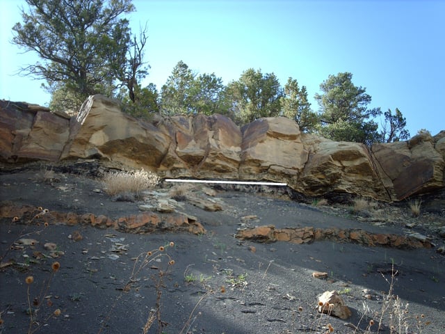 The K–Pg boundary exposure in Trinidad Lake State Park, in the Raton Basin of Colorado, shows an abrupt change from dark- to light-colored rock. White line added to mark the transition.