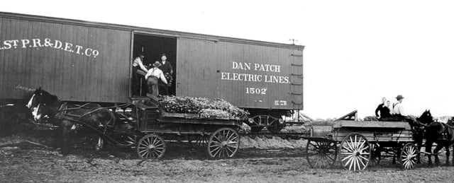 Bachman farmstead workers load produce onto a Dan Patch line boxcar for delivery to market.