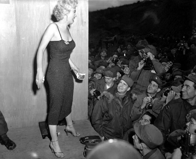 Posing for soldiers in Korea after a USO performance in February 1954, during her suspension by the studio