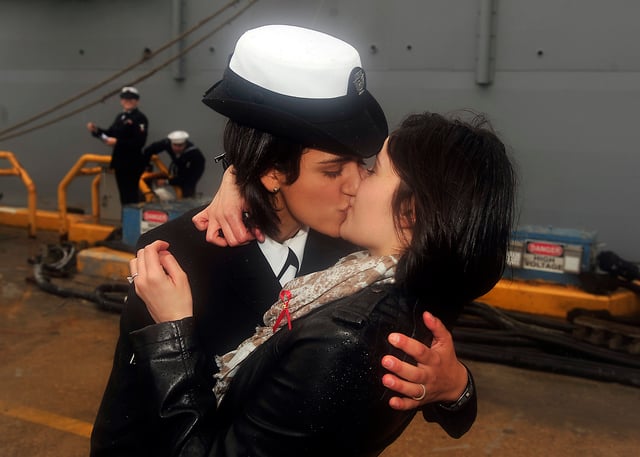 Petty Officer 2nd Class Marissa Gaeta of the USS Oak Hill (LSD-51) shares the traditional "first kiss" with her fiancée, Petty Officer 3rd Class Citlalic Snell, December 23, 2011.