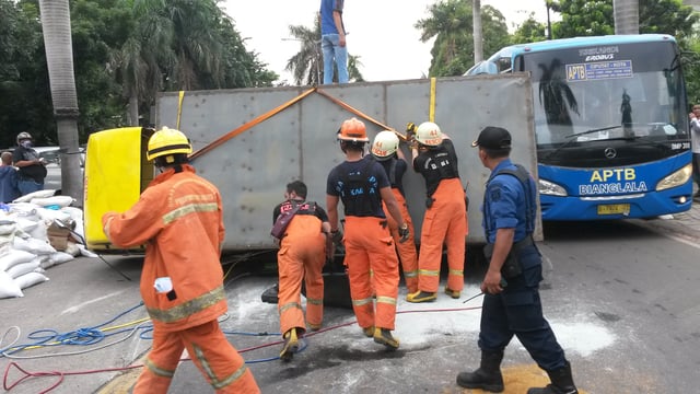 A rolled over box truck being handled by fire fighters in Jakarta, Indonesia