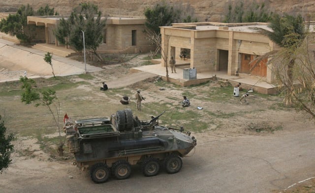 Marines from D Company, 3rd Light Armored Reconnaissance Battalion guard detainees prior to loading them into their vehicle.