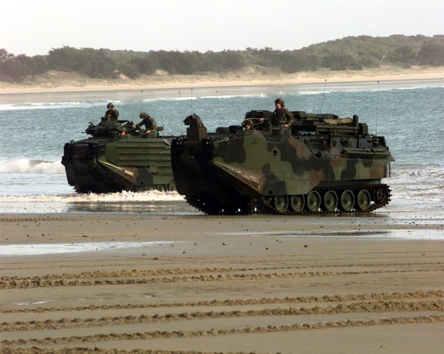 Marine Amphibious Assault Vehicles emerge from the surf onto the sand of Freshwater Beach, Australia