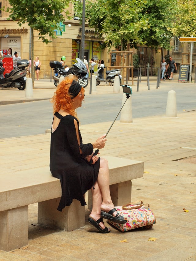 Woman taking a selfie using a selfie stick