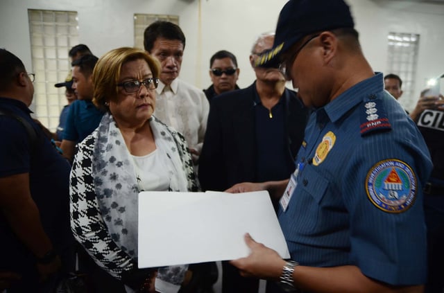 Senator Leila De Lima listens to a PNP-CIDG officer who served the warrant for her arrest at the Senate grounds in Pasay. February 24, 2017.