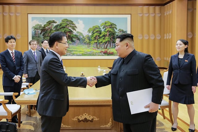 Kim (holding envelope) with Chung Eui-yong. Kim's sister Kim Yo-jong (on the right) is said to be very close to him