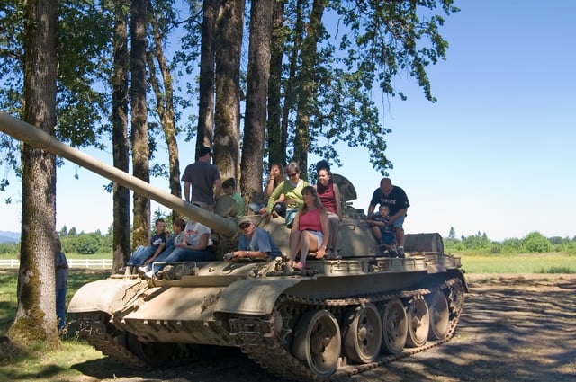 Kids climb on a Soviet T-55 behind the main building.
