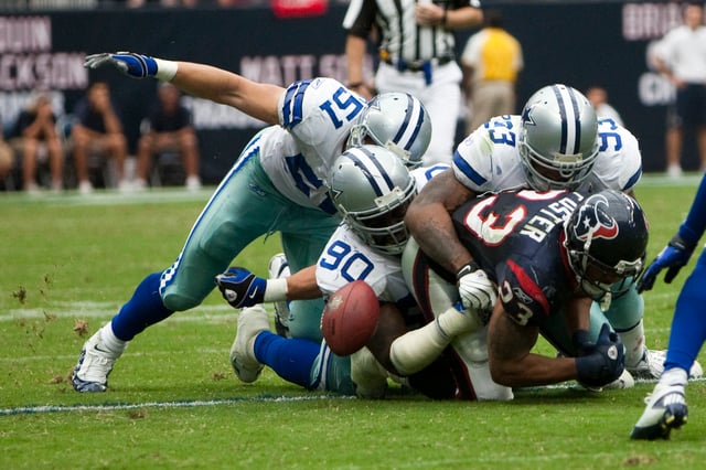 Dallas Cowboys defensive players force Houston Texans running back Arian Foster to fumble the ball