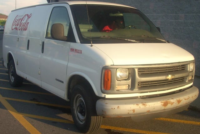 A Chevrolet Express van bearing the logo of The Coca-Cola Company.