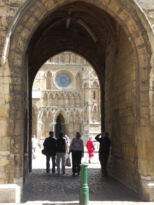 The west front of Lincoln Cathedral viewed through the Exchequer Gate, one of a number of surviving gates in the Cathedral Close walls.