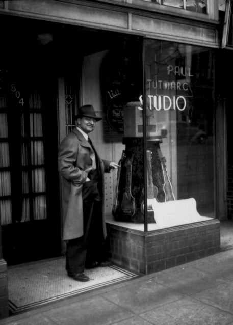 Musical instrument inventor Paul Tutmarc outside his music store in Seattle, Washington