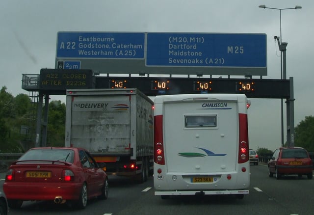 The M25 between Junctions 7 (M23) and 6 (A22) near Redhill, Surrey. The signs are indicating an advisory reduced speed of 40 mph (64 km/h) due to congestion.