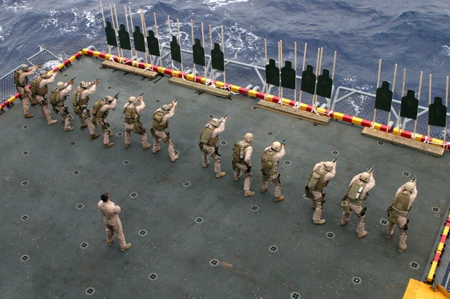 Marines firing the MEU(SOC) pistol while garrisoned aboard a ship