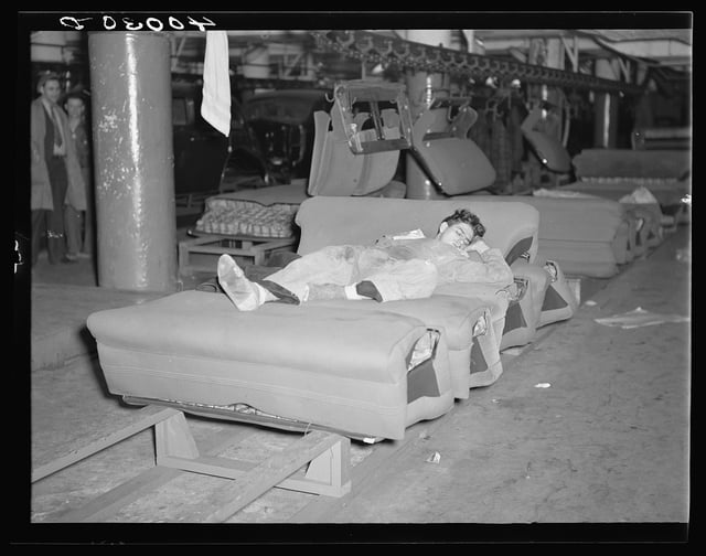 Young striker off sentry duty sleeping on assembly line of auto seats