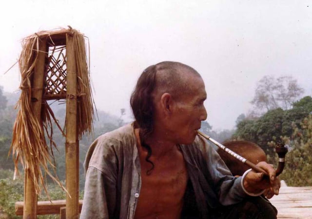 An Akha man smokes a pipe containing opium mixed with tobacco