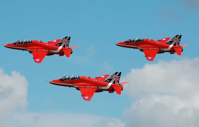 The RAF Red Arrows depart the 2014 Royal International Air Tattoo, England, in a colour scheme that commemorates their 50th year.