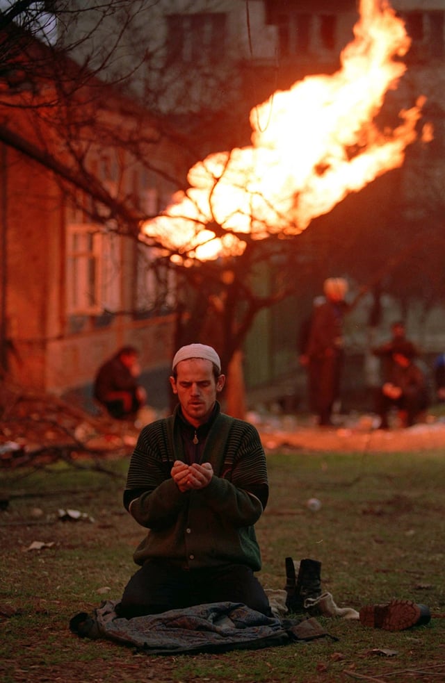 A Chechen man prays during the Battle of Grozny.