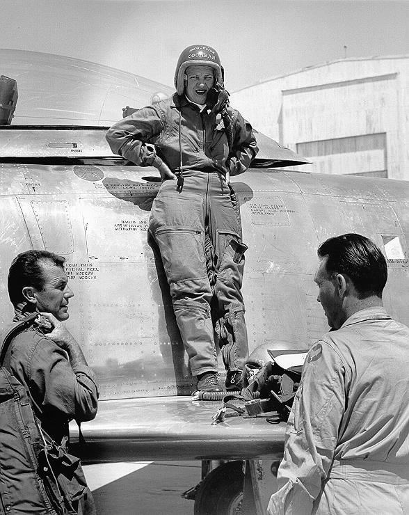 Cochran standing on the wing of her F-86 talking to Chuck Yeager and Canadair's chief test pilot Bill Longhurst