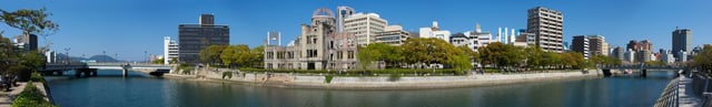 Panoramic view of Hiroshima Peace Memorial Park. The Genbaku Dome can be seen in the center left of the image. The original target for the bomb was the "T"-shaped Aioi Bridge seen in the left of the image.