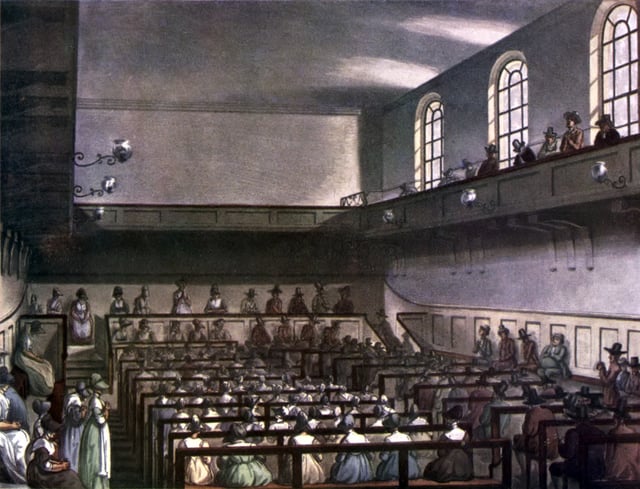 Conservative Friends worshipping in London in 1809. Friends are in traditional plain dress. At the front of the meeting house, the Recorded Ministers sit on a raised ministers' gallery facing the rest of the meeting, with the elders sitting on the bench in front of them, also facing the meeting. Men and women are segregated, but both are able to minister.