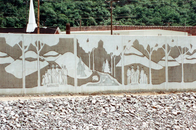 A section of the flood wall along the Tug Fork in Matewan, West Virginia, constructed by the U.S. Army Corps of Engineers, depicts the Hatfield–McCoy feud.