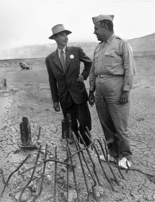 Oppenheimer and Groves at the remains of the Trinity test in September 1945, two months after the test blast and just after the end of World War II. The white overshoes prevented fallout from sticking to the soles of their shoes.