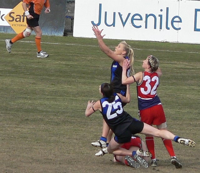 Melbourne University women's football player jostles for best position in a marking contest