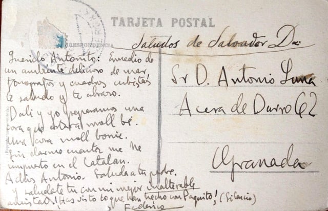 Postcard from Lorca and Dalí to Antonio de Luna, signed "Federico." "Dear Antonito: In the midst of a delicious ambience of sea, phonographs and cubist paintings I greet you and I hug you. Dalí and I are preparing something that will be 'moll bé.' Something 'moll bonic.' Without realizing it, I have deposited myself in the Catalan. Goodbye Antonio. Say hello to your father.  And salute yourself with my finest unalterable friendship. You've seen what they've done with Paquito! (Silence)"  Above, penned by Dalí: "Greetings from Salvador Dalí"