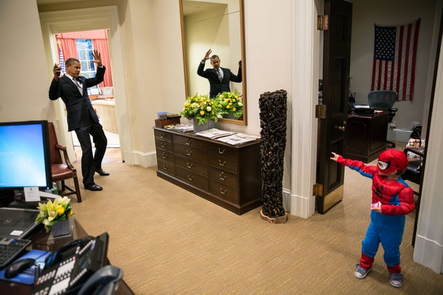 U.S. President Barack Obama pretending to be webbed up by a boy dressed in a Spider-Man costume inside the White House