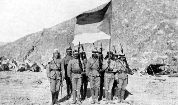 Soldiers of the Hashemite-led Arab Army holding the flag of the Great Arab Revolt in 1916.