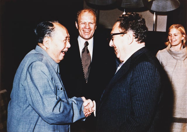 U.S. President Gerald Ford watches as Henry Kissinger shakes hands with Mao during their visit to China, December 2, 1975