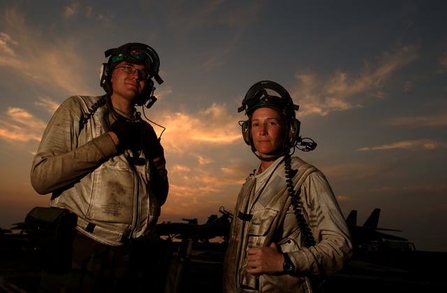 AD2 Corey Villasana and AD1 Julie Hollars of VFA-115 prepare for duty as flight deck troubleshooters during night operations on board USS Abraham Lincoln (CVN-72)