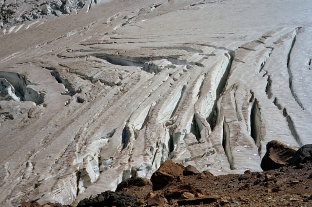 Shear or herring-bone crevasses on Emmons Glacier (Mount Rainier); such crevasses often form near the edge of a glacier where interactions with underlying or marginal rock impede flow. In this case, the impediment appears to be some distance from the near margin of the glacier.