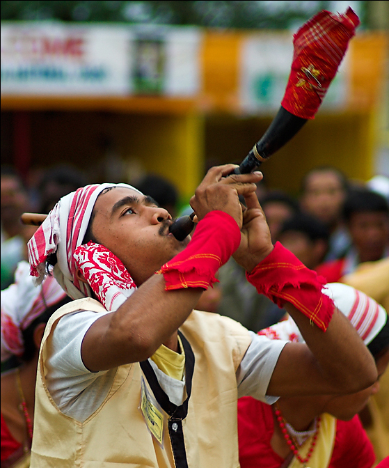 A Bihu dancer blowing a pepa (horn)