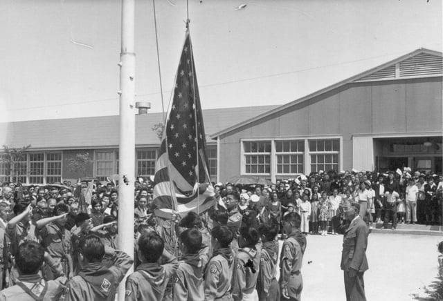 Boy Scouts at the Granada War Relocation Center raise the flag to half-mast during a memorial service for the first six Nisei soldiers from this Center who were killed in action in Italy. The service was attended by 1,500 Amache internees. August 5, 1944.