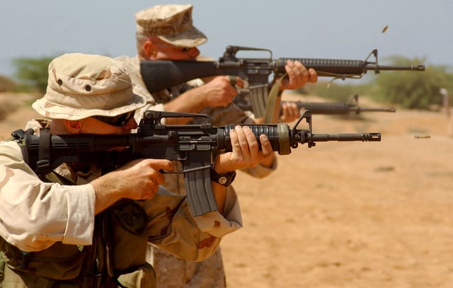 An M4A1 carbine (foreground) and two M16A2s (background) being fired by U.S. Marines during a live fire exercise: though adopted in the 1990s and derived from the M16A2, the M4 carbine was part of a long line of short-barreled AR-15 used in the U.S. military