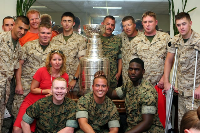 July 13, 2006: Wounded United States Marines pose with Carolina Hurricanes star Glen Wesley (in orange shirt) and the Stanley Cup