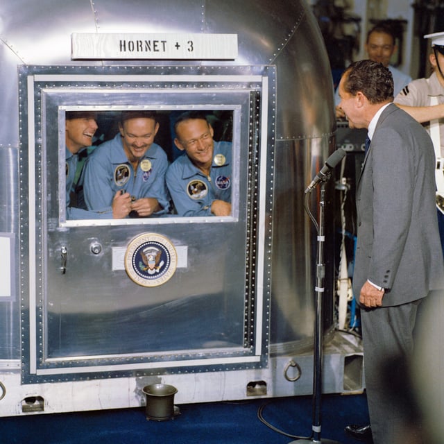 The Apollo 11 crew and President Nixon during the post-mission quarantine period.