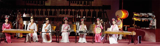 Replica instruments of ancient originals are played at the Hubei Provincial Museum.A replica set of bronze concert bells is in the background and a set of stone chimes is to the right.