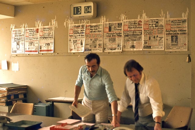 Editors work on producing an issue of Bild, West Berlin, 1977. Previous front pages are affixed to the wall behind them.
